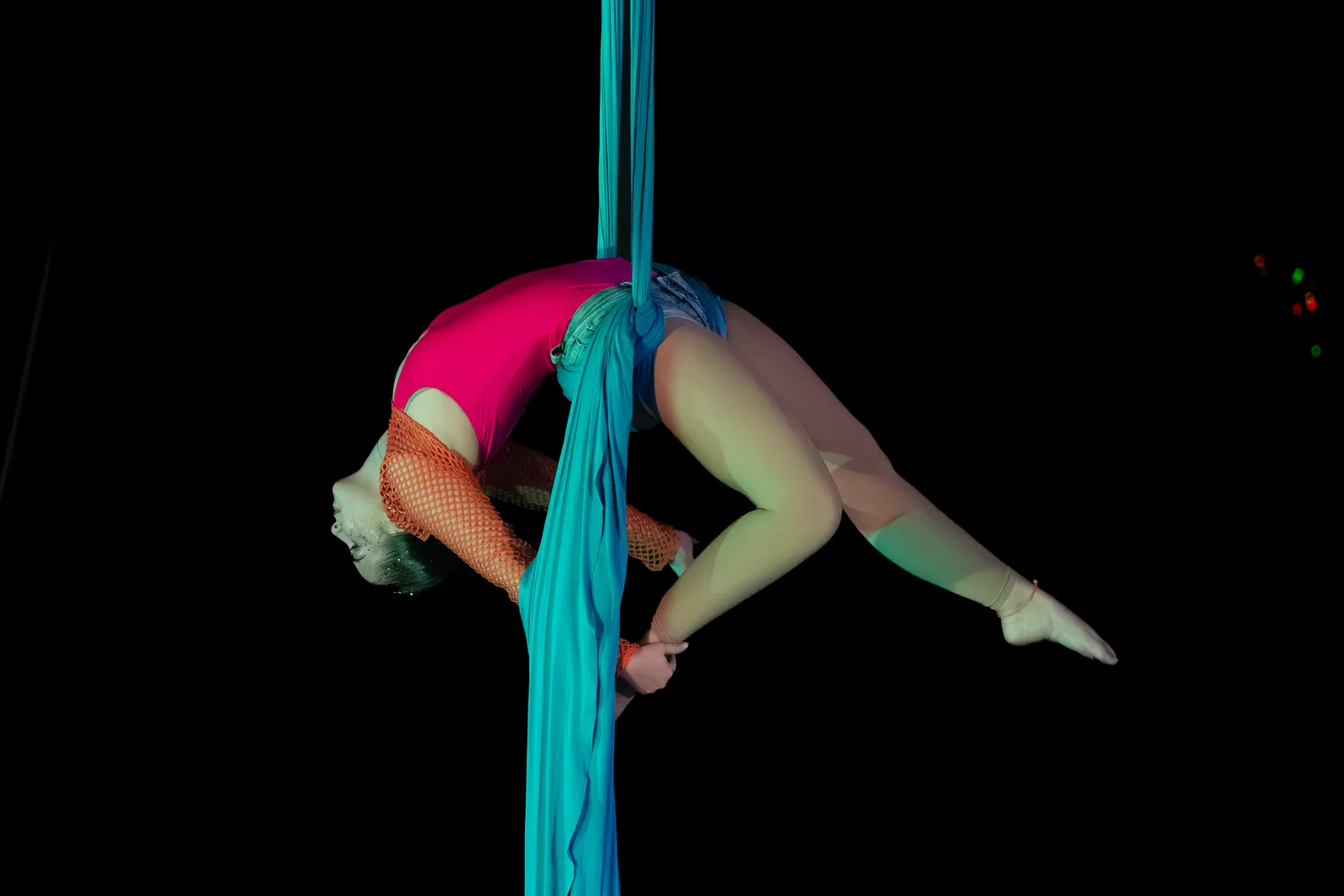 Figura in arco sui tessuti aerei sotto le luci di scena — Free Harmony Dance Time